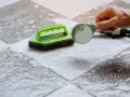 Nettoyer un carrelage mat et poreux avec une brosse et une poudre nettoyante.