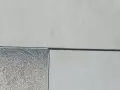 Détail d'un sol extérieur avec des dalles claires et une zone de gravier, montrant la précision du couper carrelage.