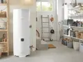 Un préparateur ECS Atlantic blanc trône dans un garage bien rangé, prêt à fournir de l'eau chaude.