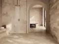 Douche moderne avec carrelage effet pierre naturelle. Quel carrelage pour salle de bain ? Ce choix de tons chauds et de textures variées crée une ambiance zen et luxueuse.