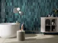 Une grande salle de bain moderne avec baignoire îlot, carrelage mural bleu sarcelle texturé et meuble de rangement élégant.