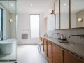 Plan salle de bain rectangulaire moderne avec baignoire, double vasque et rangements en bois.