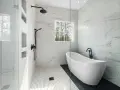 Salle de bain moderne avec baignoire îlot et douche vitrée, murs en porcelaine ou céramique effet marbre.