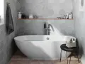 Salle de bain moderne avec baignoire îlot, carrelage mural hexagonal gris et étagère en bois.