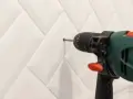 Une perceuse est utilisée pour percer le carrelage de la salle de bain.