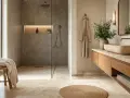 Élégante salle de bain en travertin avec douche à l'italienne, lavabo en pierre naturelle et peignoir suspendu.