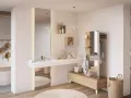 Salle de bain ouverte sur chambre, avec baignoire, lavabo, miroir, et mobilier en bois. Ambiance épurée et naturelle.