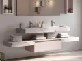 Salle de bain moderne avec double vasque en **solid surface** marbré, rangements suspendus et serviettes douces.