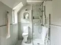 Plan salle de bain en longueur avec douche, WC et échelle décorative.