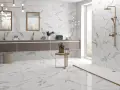Salle de bain moderne avec carrelage imitation marbre en grès cérame pleine masse. Doubles vasques, douche à l'italienne, et touches dorées.