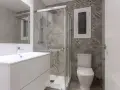 Salle de bain moderne avec douche vitrée, lavabo suspendu et carrelage graphique. Un projet pour agrandir salle de bain avec style.