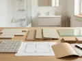 Échantillons de carrelage, plans et matériaux pour refaire une salle de bain budget.