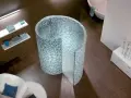 Une douche escargot aux mosaïques bleues et vertes, avec une baignoire et un fauteuil dans une salle de bain moderne.
