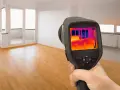 Caméra thermique utilisée pour comment detecter une fuite d'eau sous un carrelage. L'écran montre des variations de température, indiquant une potentielle humidité.