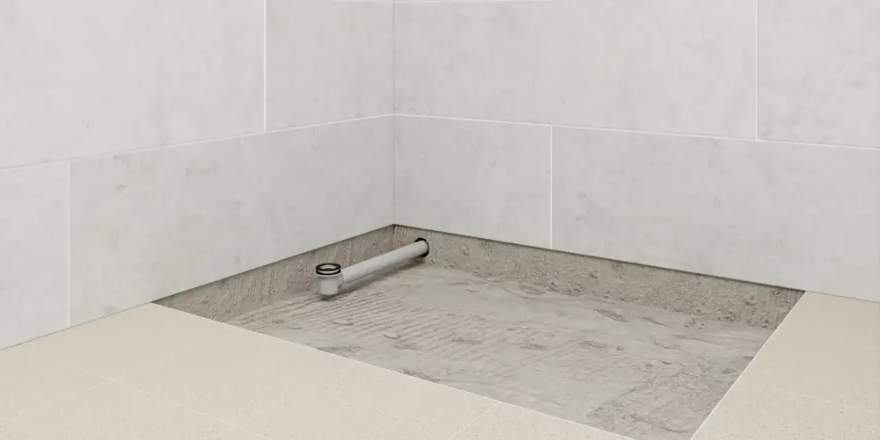 Installation d'un receveur de douche entre trois murs, avec évacuation visible.