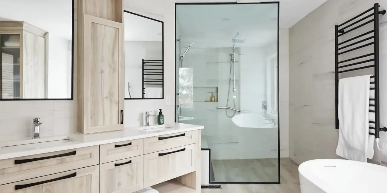 Salle de bain moderne avec double vasque en bois clair, douche vitrée et baignoire îlot. Un design épuré pour une ambiance zen.