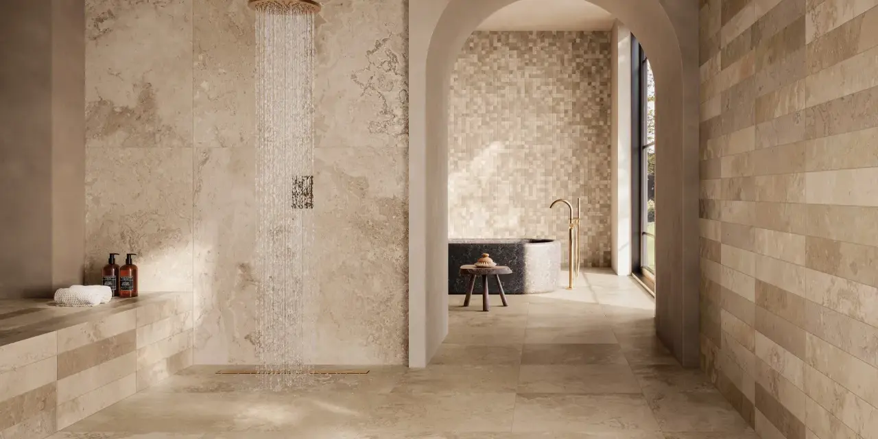 Douche moderne avec carrelage effet pierre naturelle. Quel carrelage pour salle de bain ? Ce choix de tons chauds et de textures variées crée une ambiance zen et luxueuse.