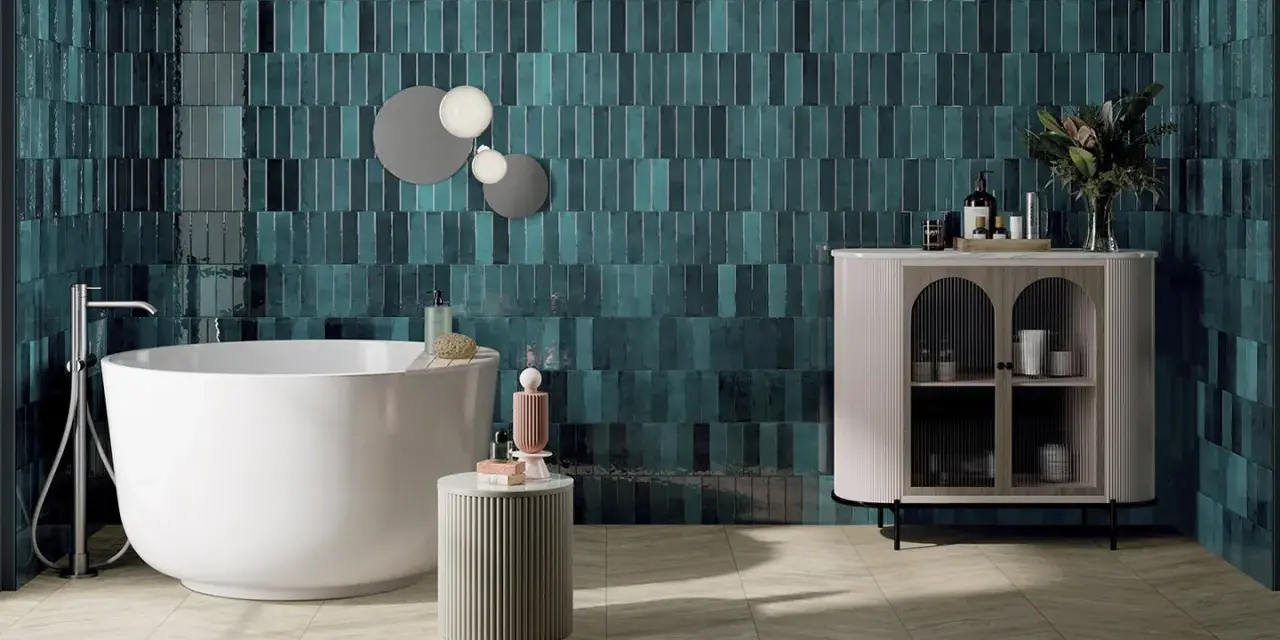 Une grande salle de bain moderne avec baignoire îlot, carrelage mural bleu sarcelle texturé et meuble de rangement élégant.