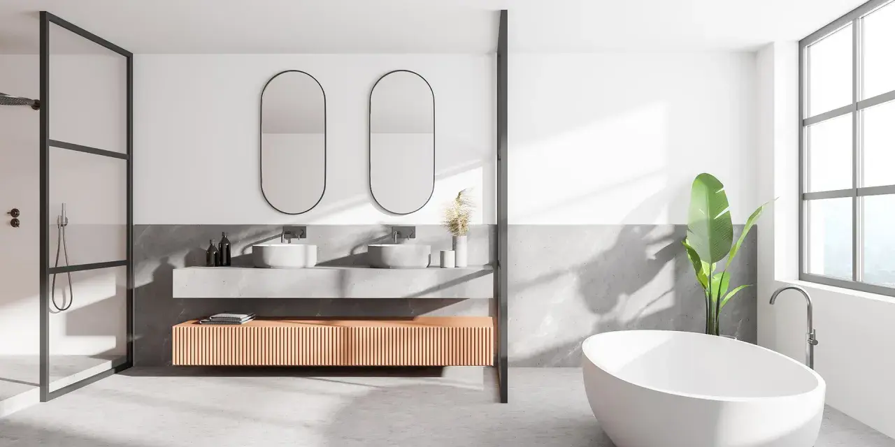 Salle de bain moderne avec baignoire îlot, double vasque et douche. Le sol en béton ciré, un carrelage sans joint, crée une ambiance épurée et contemporaine.