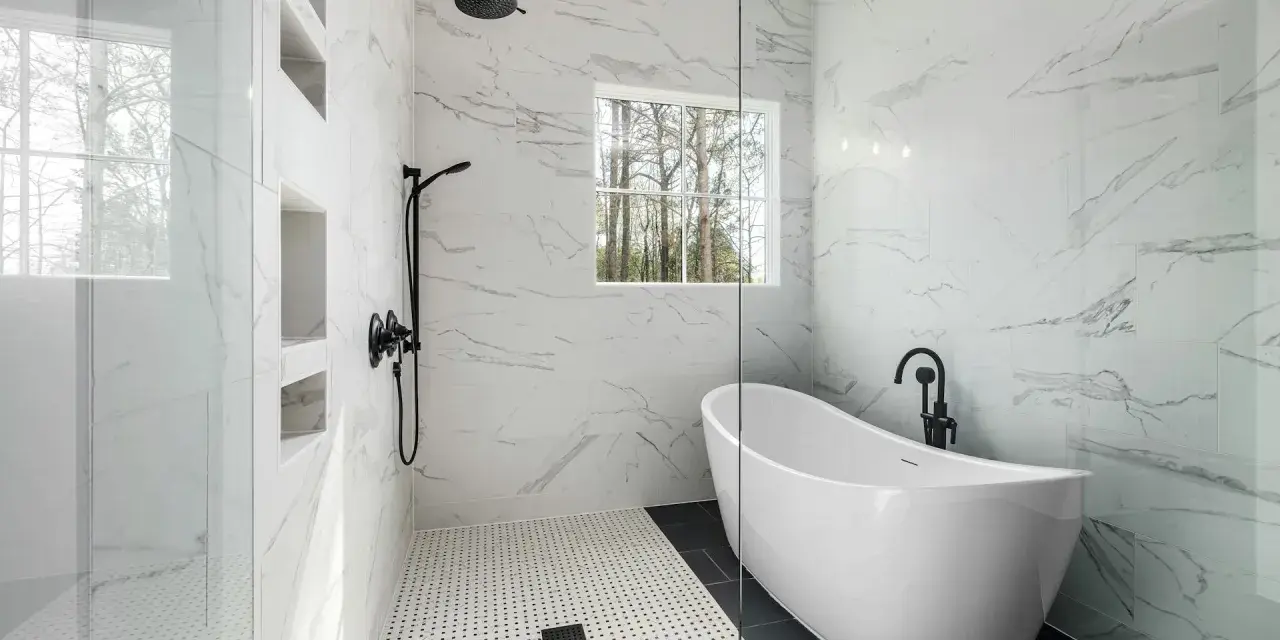 Salle de bain moderne avec baignoire îlot et douche vitrée, murs en porcelaine ou céramique effet marbre.