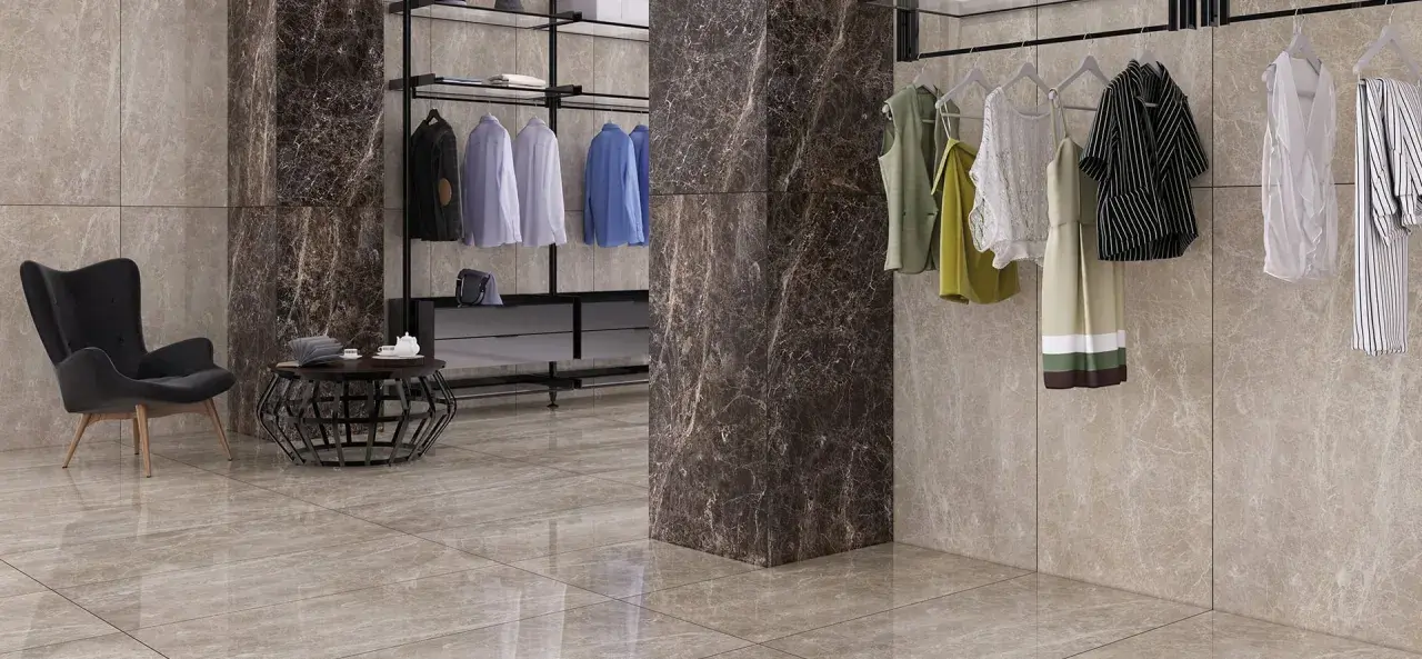 Un dressing moderne avec des vêtements suspendus, un fauteuil noir et un sol en lappato carrelage aux tons taupe.
