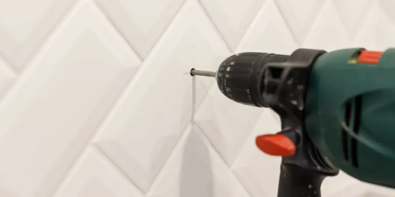 Une perceuse est utilisée pour percer le carrelage de la salle de bain.