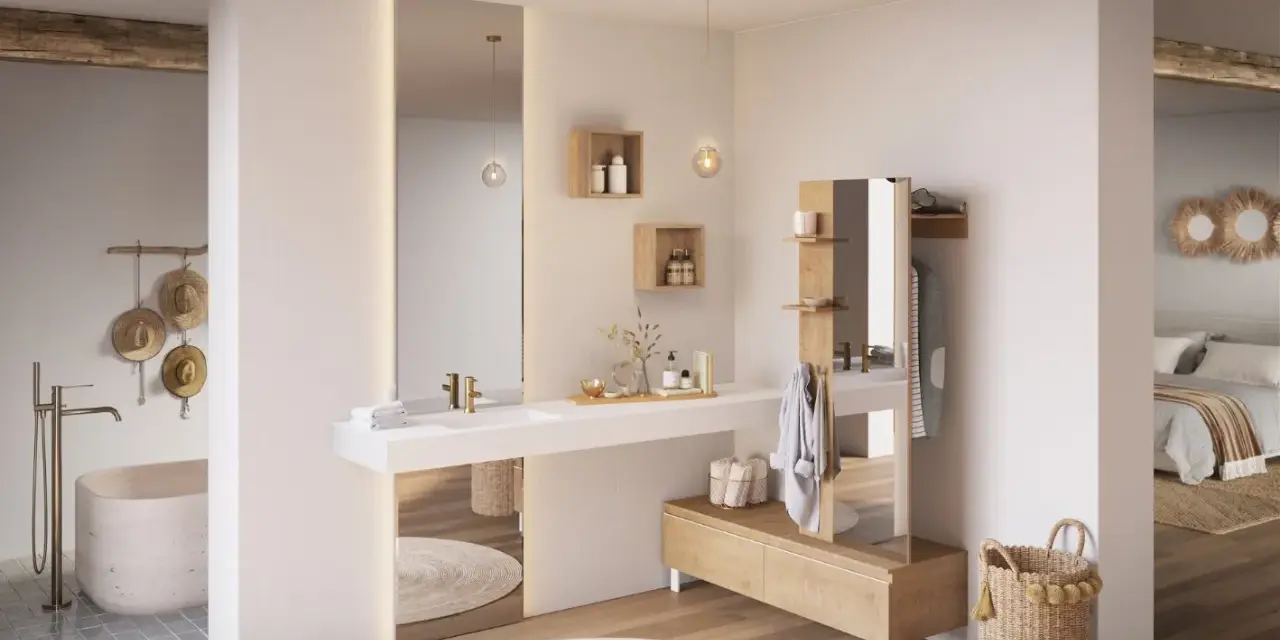 Salle de bain ouverte sur chambre, avec baignoire, lavabo, miroir, et mobilier en bois. Ambiance épurée et naturelle.