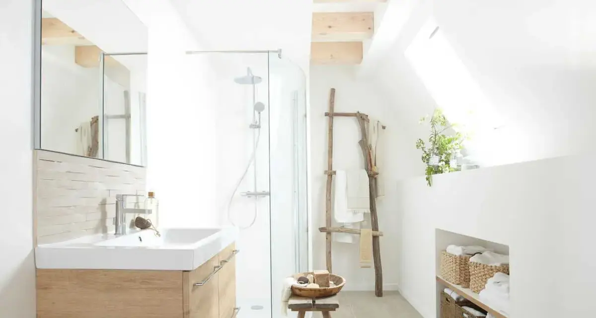 Salle de bain lumineuse avec douche, lavabo en bois clair et paniers de rangement. Un style de wet room épuré et naturel.
