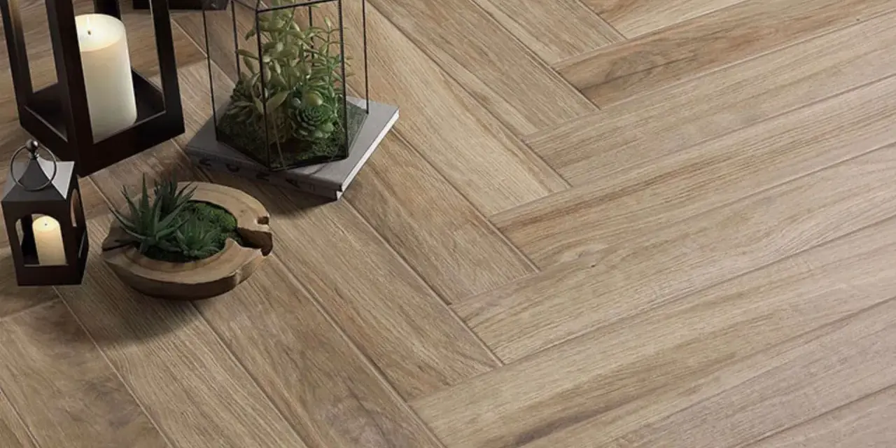 Sol en carrelage imitation bois, pose en chevron. Lanternes, bougies et plantes apportent une touche chaleureuse.