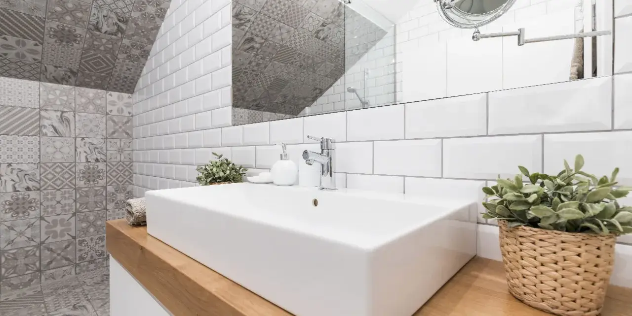 Une salle de bain moderne avec un lavabo rectangulaire blanc, un mur de carrelage métro blanc et un mur de carrelage décoratif gris. Une belle idée carrelage petite salle de bain.