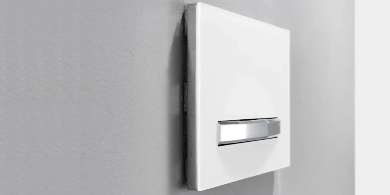 Plaque de déclenchement blanche avec double poussoir chromé pour une chasse d'eau à double débit, optimisant la consommation d'eau.