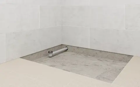 Installation d'un receveur de douche entre trois murs, avec évacuation visible.