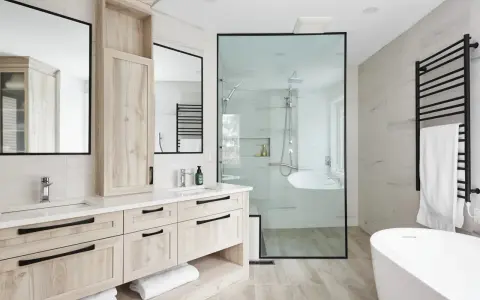 Salle de bain moderne avec double vasque, douche vitrée et baignoire îlot. Une belle rénovation baignoire pour un espace épuré.