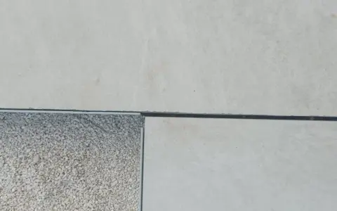 Détail d'un sol extérieur avec des dalles claires et une zone de gravier, montrant la précision du couper carrelage.