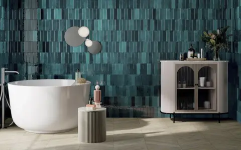 Une grande salle de bain moderne avec baignoire îlot, carrelage mural bleu sarcelle texturé et meuble de rangement élégant.