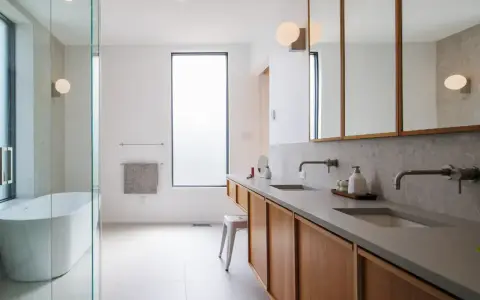 Plan salle de bain rectangulaire moderne avec baignoire, double vasque et rangements en bois.