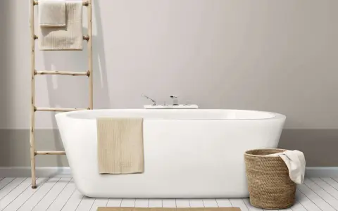 Baignoire moderne avec robinetterie chromée. Un porte-serviettes en bois et un panier en osier complètent l'ensemble, suggérant un émail baignoire poreux à l'aspect naturel.