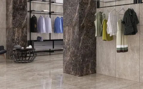 Un dressing moderne avec des vêtements suspendus, un fauteuil noir et un sol en lappato carrelage aux tons taupe.