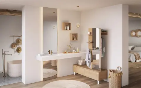 Salle de bain ouverte sur chambre, avec baignoire, lavabo, miroir, et mobilier en bois. Ambiance épurée et naturelle.