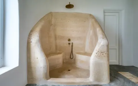 Douche à l'italienne en résine sculptée, avec bancs intégrés. Un inconvénient : le nettoyage peut être délicat.