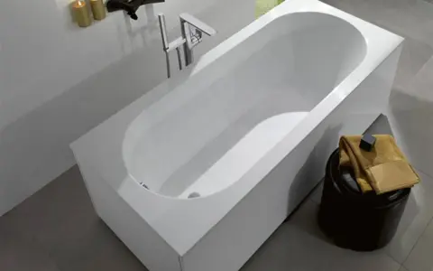Une baignoire moderne et épurée, idéale pour vous aider à choisir comment choisir sa baignoire. Un robinet chromé et des bougies apportent une touche de luxe.