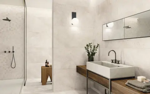 Salle de bain moderne avec carrelage 60x120 pose décalée, douche vitrée, vasque en pierre et meuble en bois.