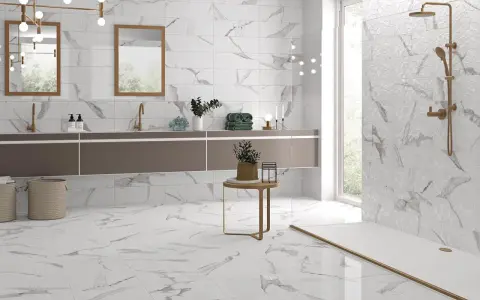 Salle de bain moderne avec carrelage imitation marbre en grès cérame pleine masse. Doubles vasques, douche à l'italienne, et touches dorées.