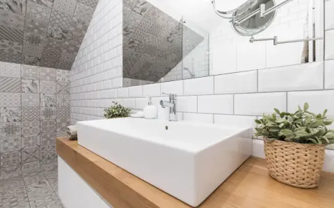 Une salle de bain moderne avec un lavabo rectangulaire blanc, un mur de carrelage métro blanc et un mur de carrelage décoratif gris. Une belle idée carrelage petite salle de bain.