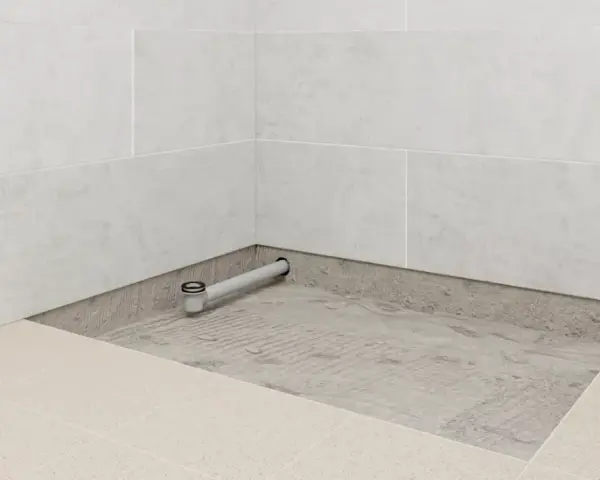 Installation d'un receveur de douche entre trois murs, avec évacuation visible.