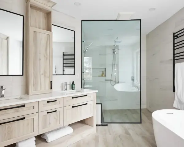 Salle de bain moderne avec double vasque, douche vitrée et baignoire îlot. Une belle rénovation baignoire pour un espace épuré.