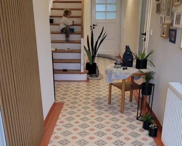 Un enfant sur les escaliers, un sol avec une peinture carrelage aux motifs floraux. La durée de vie de ce revêtement est impressionnante.