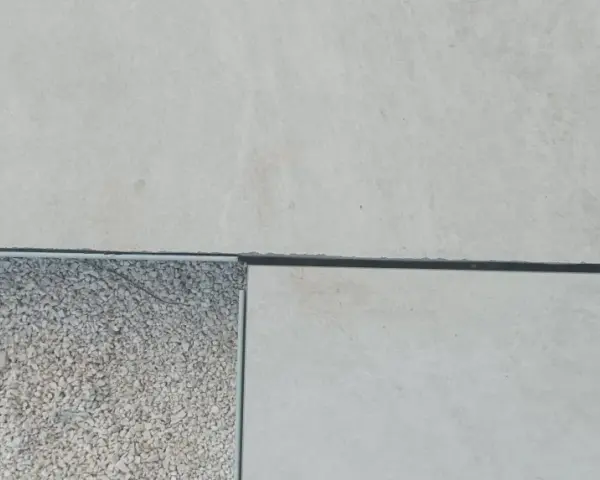 Détail d'un sol extérieur avec des dalles claires et une zone de gravier, montrant la précision du couper carrelage.