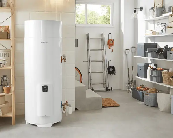 Un préparateur ECS Atlantic blanc trône dans un garage bien rangé, prêt à fournir de l'eau chaude.