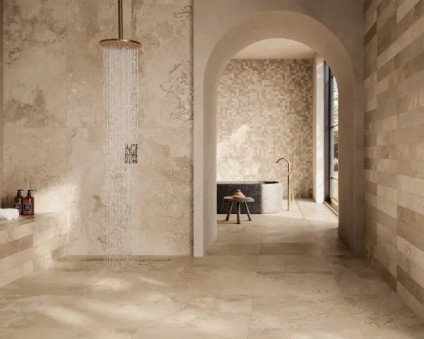 Douche moderne avec carrelage effet pierre naturelle. Quel carrelage pour salle de bain ? Ce choix de tons chauds et de textures variées crée une ambiance zen et luxueuse.